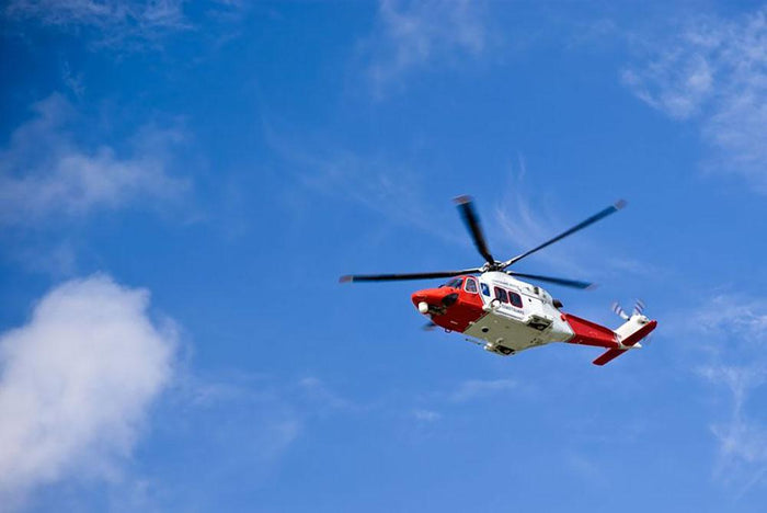 Coastguard helicopter in the blue sky Wall Mural Wallpaper