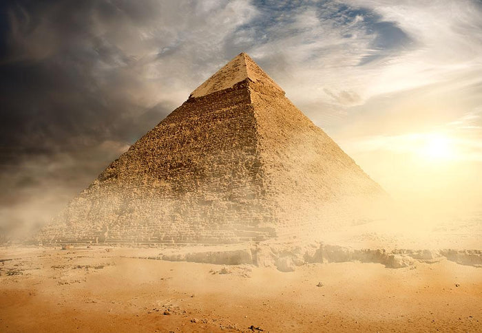 Pyramid in sand dust under clouds Wall Mural Wallpaper