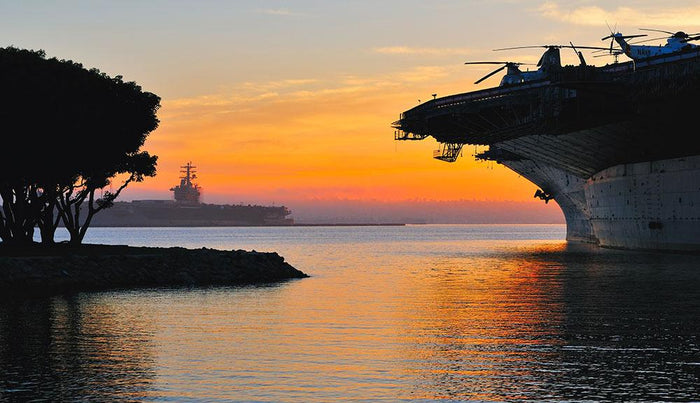 aircraft carrier in harbour in sunset Wall Mural Wallpaper